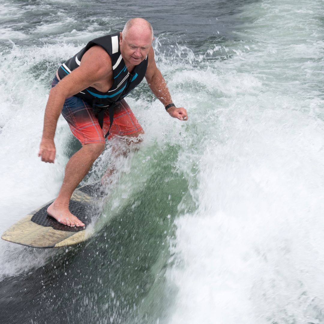 Baby boomer on a surfboard in the water