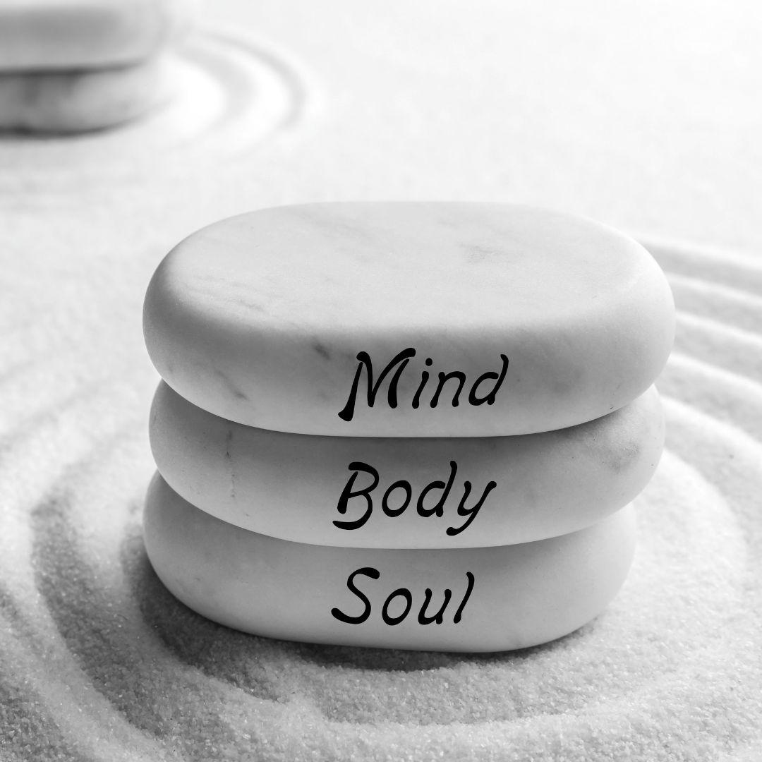 White rocks and sand with text reading mind body and soul