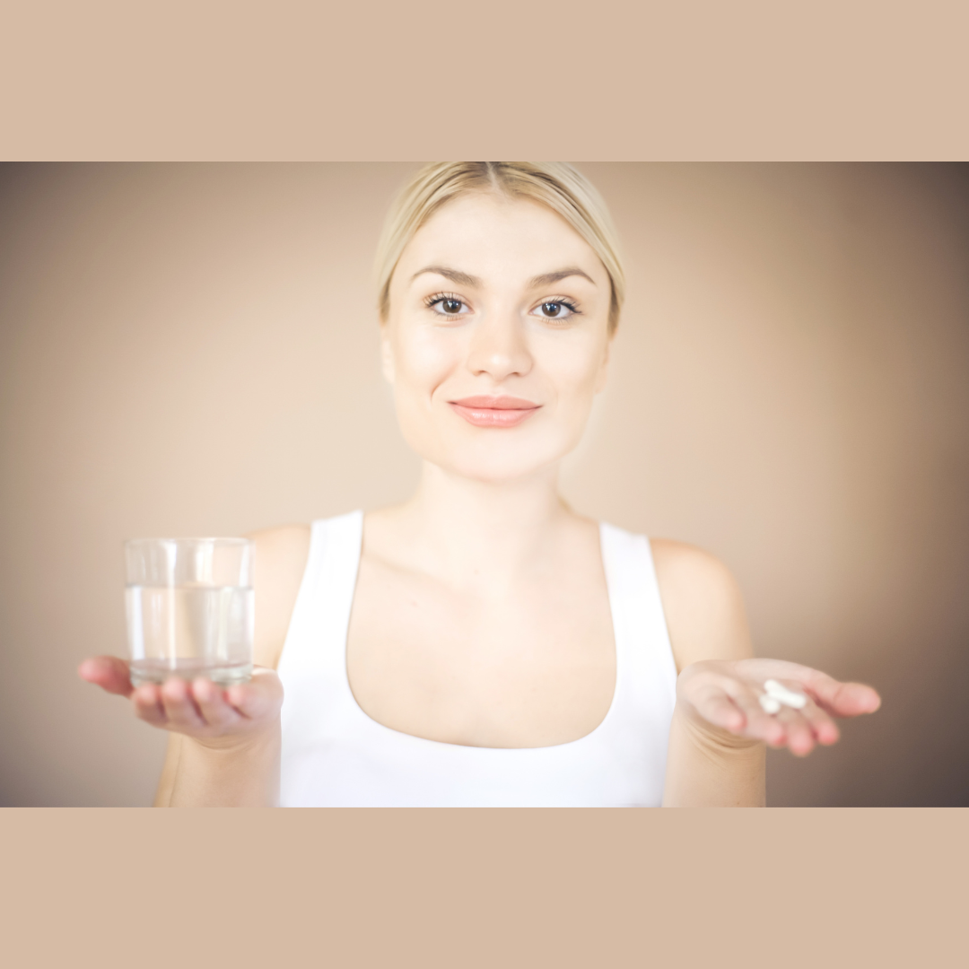 Person holding nutritional supplements and glass of water